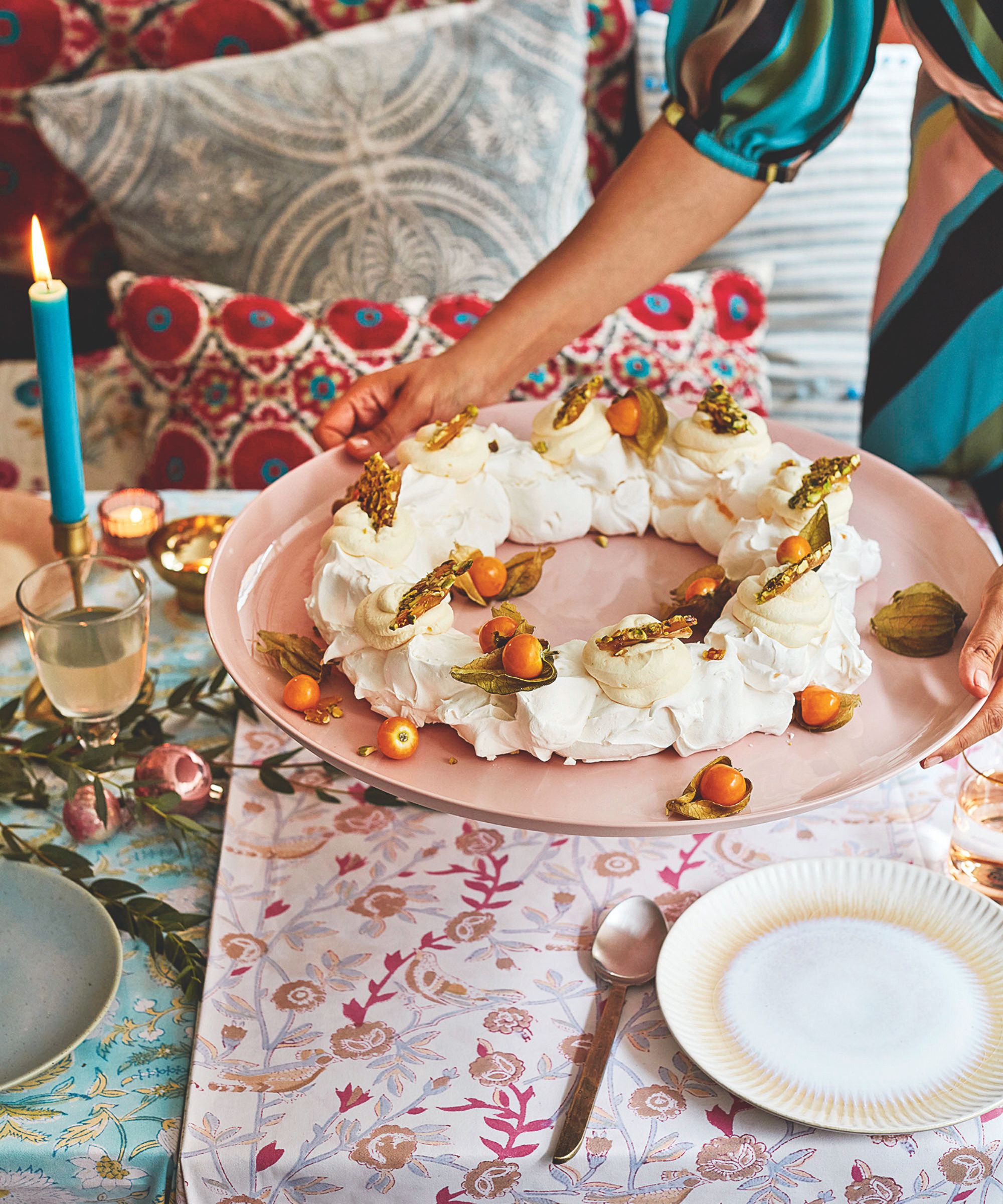 Woman placing a festive pavlova on a decorated table
