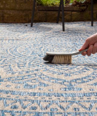 blue and white outdoor rug with brush