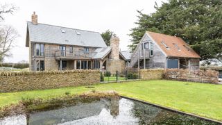 oak frame self build with matching annexe and pond