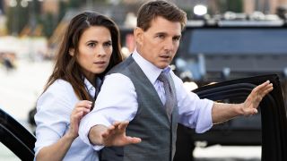 Tom Cruise tries to shield Hayley Atwell beside a car in Mission: Impossible - Dead Reckoning Part One.
