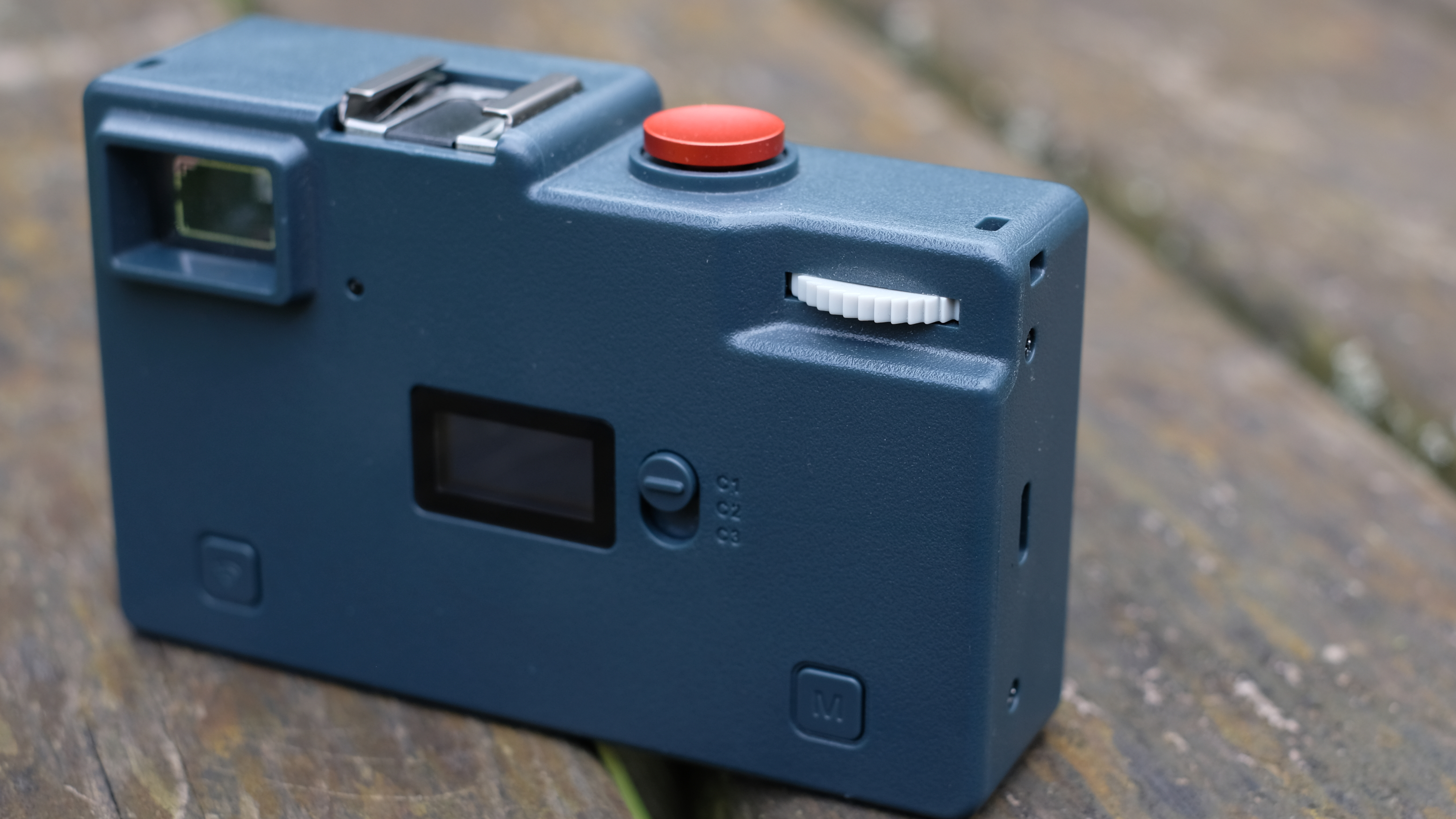 Photograph of RewindPix digital compact camera rear view with winding wheel visible.