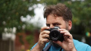 Adam Juniper holding a Sony A7 iii and kit lens