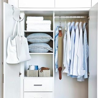 white coloured cupboard with cushion and white bag