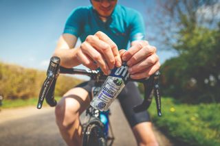 Cyclist opens a gel with caffeine