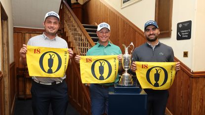 Three golfers pose with Open Championship flags and the Claret Jug