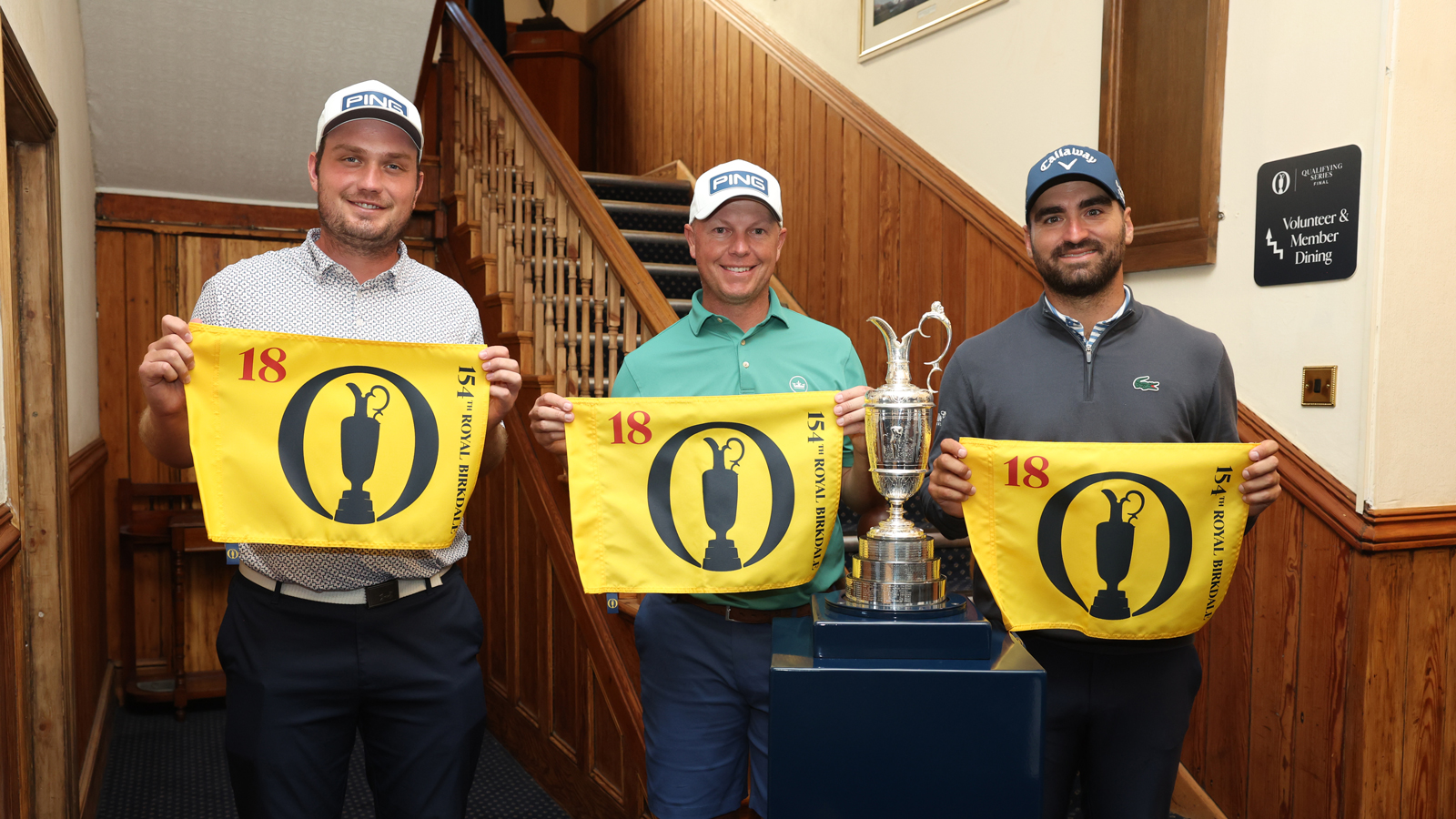 Three golfers pose with Open Championship flags and the Claret Jug