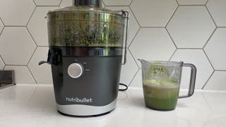 Nutribullet Juicer on a kitchen countertop with green juice