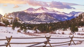 The summit of Longs Peak glows at sunrise after a fresh snowfall in Estes Park Colorado