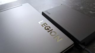 Legion Slim 7i (Gen 8) laptop lid close up with Legion logo and AC power brick