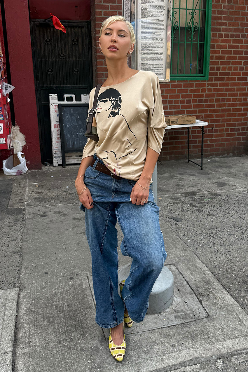 a woman wearing a graphic tee, blue jeans, and yellow heels
