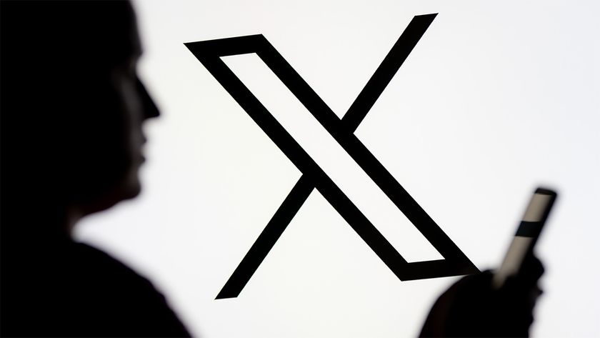 Black and white X logo with blurry person holding a smartphone in the foreground