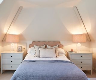 pastel bedroom with pink bedside lamps and sloping ceiling