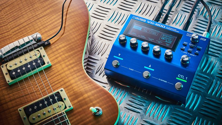 A Boss VG-800 guitar processor pedal and electric guitar lying on a sheet of metal