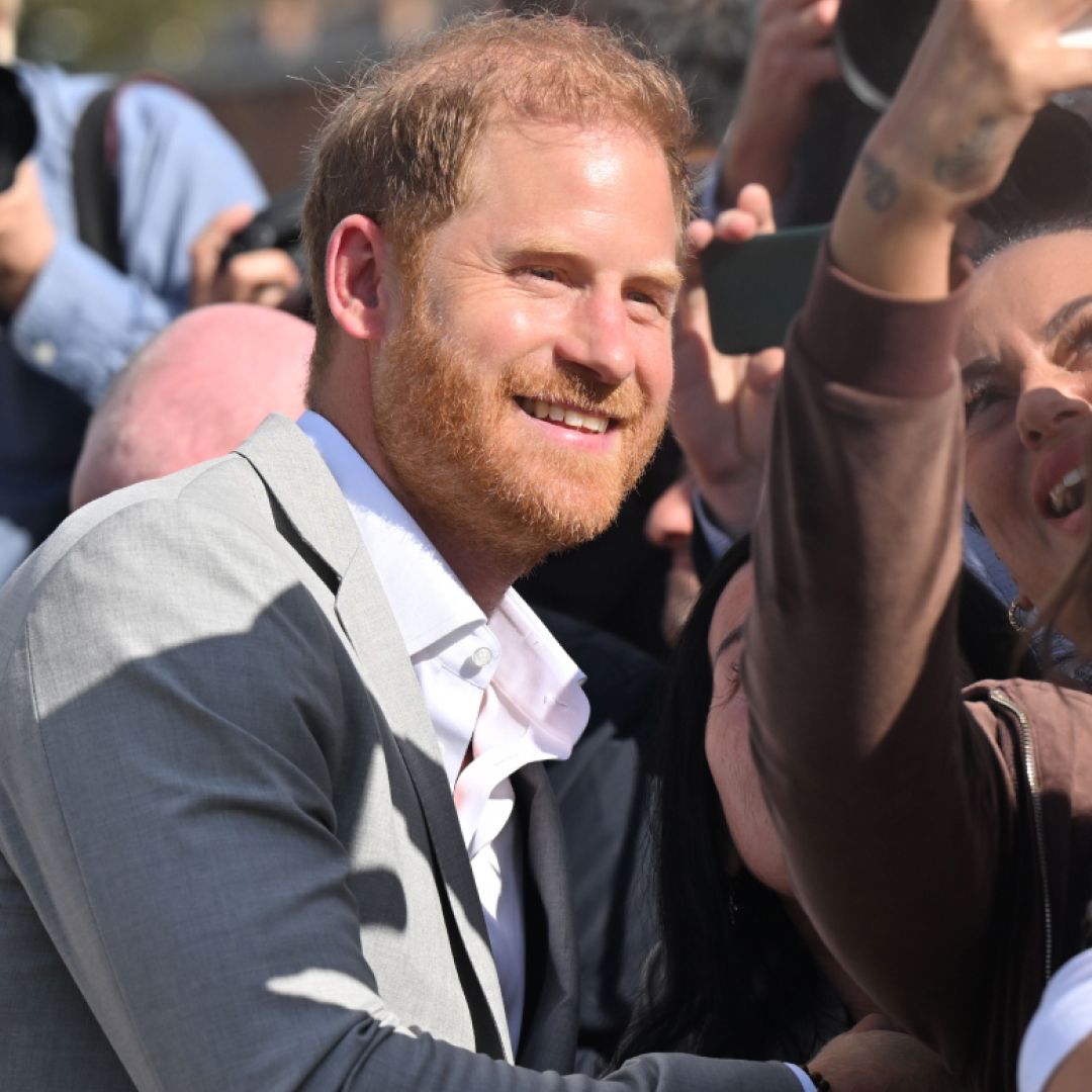 Prince Harry posing with a fan for a selfie