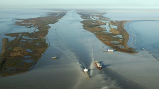An aerial view of two boats crossing each other at the mouth of the Mississippi River.