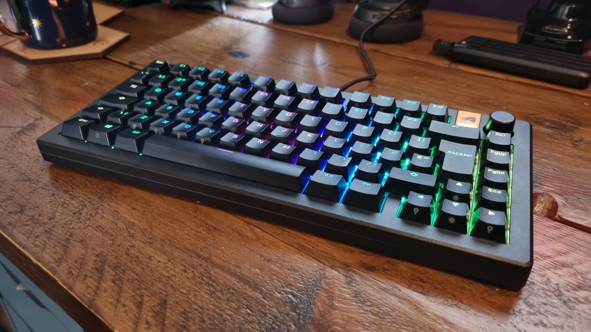 The Glorious GMMK 3 HE on a wooden desk, lit up in multicoloured RGB.