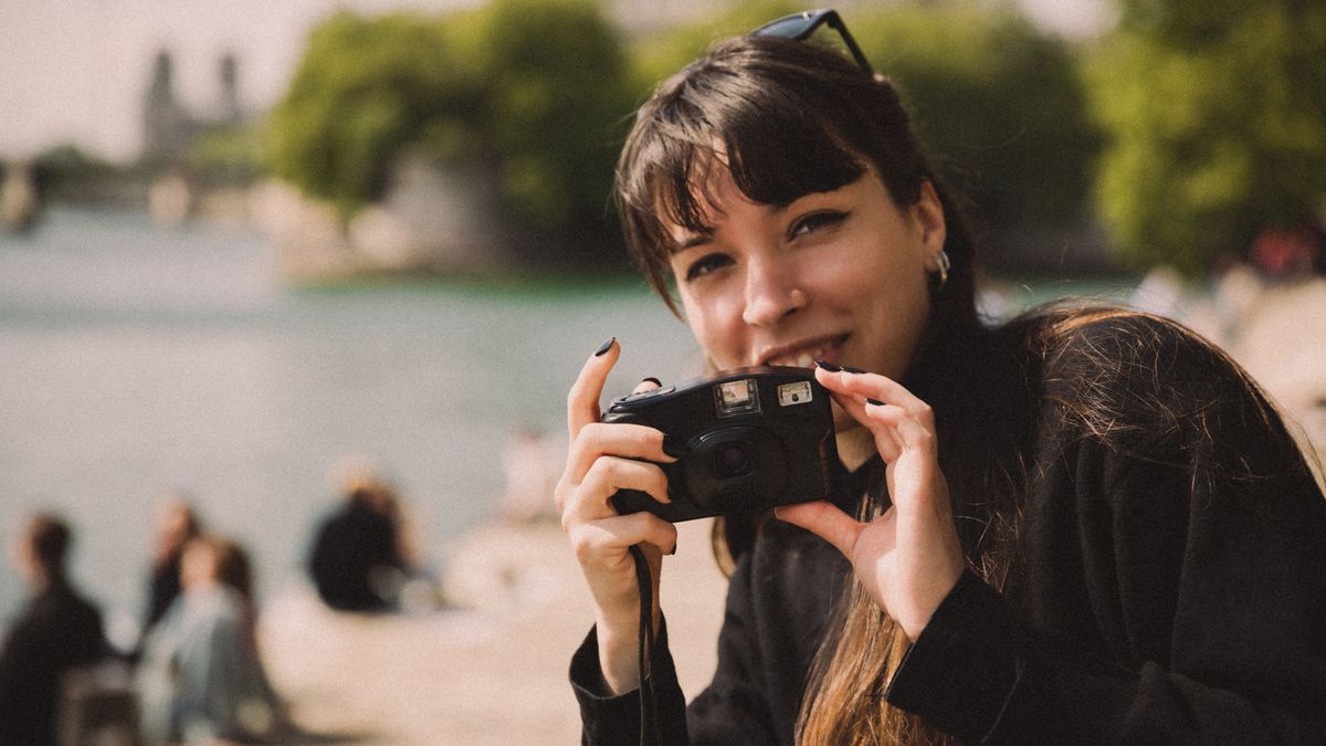 A person holds a retro compact camera