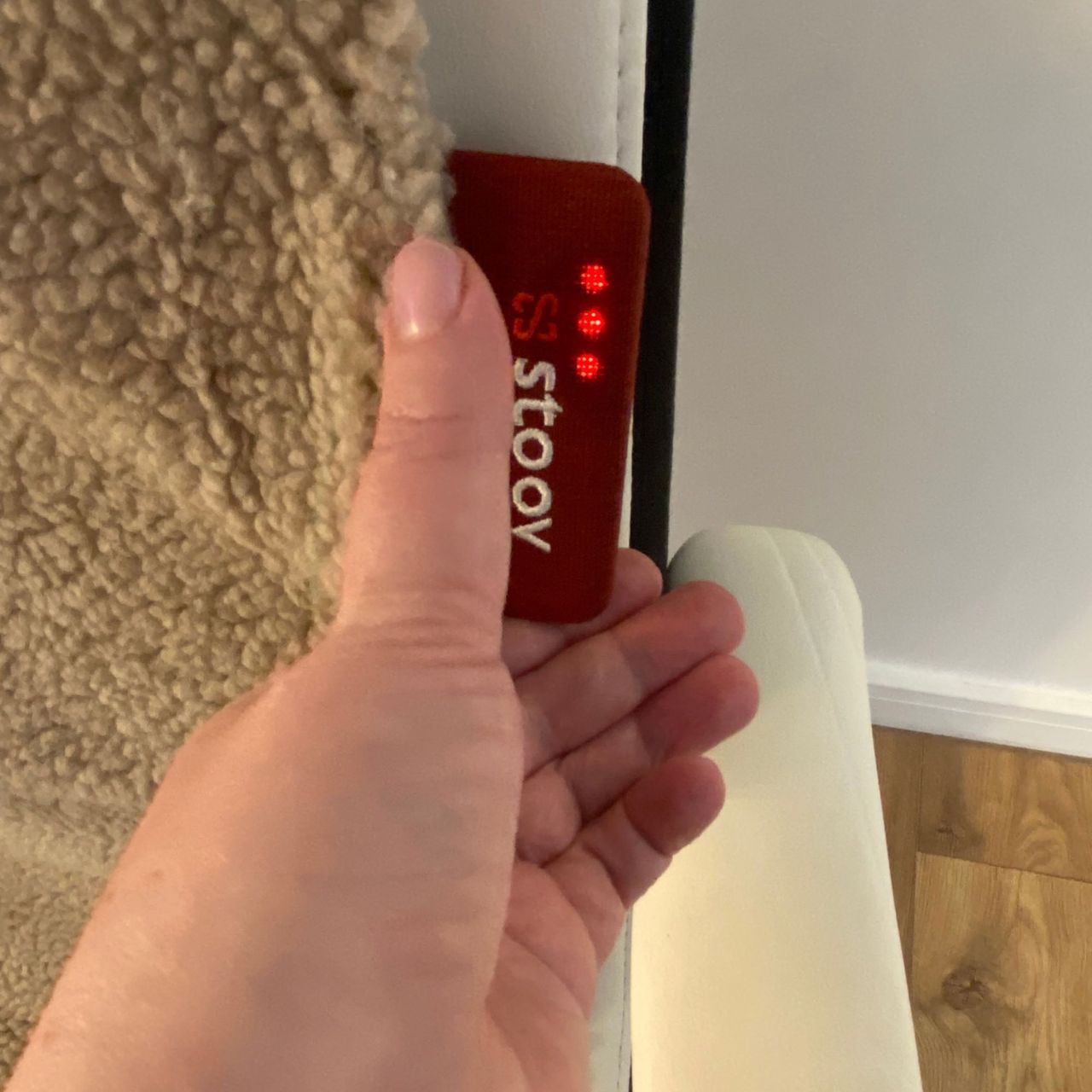 Hand pushing the button on the Stoov Big Hug3 smart label to put it into high heat mode, indicated by three lights