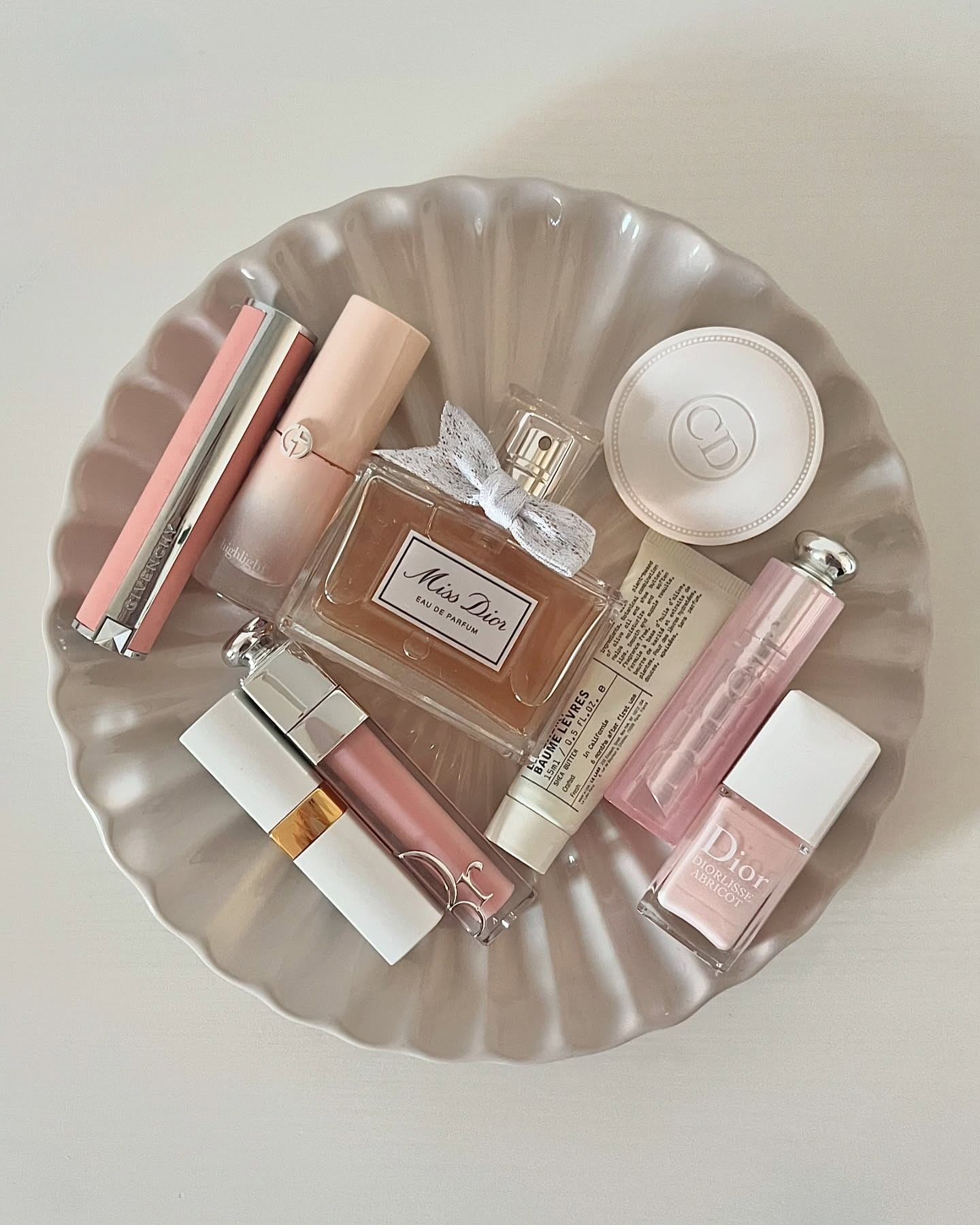 A white tray filled with beauty products including the Miss Dior perfume