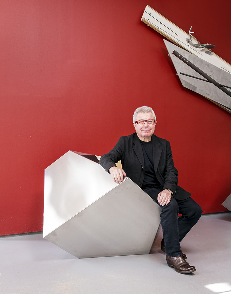 portrait of architect daniel libeskind sat in geometric chair against bold red wall