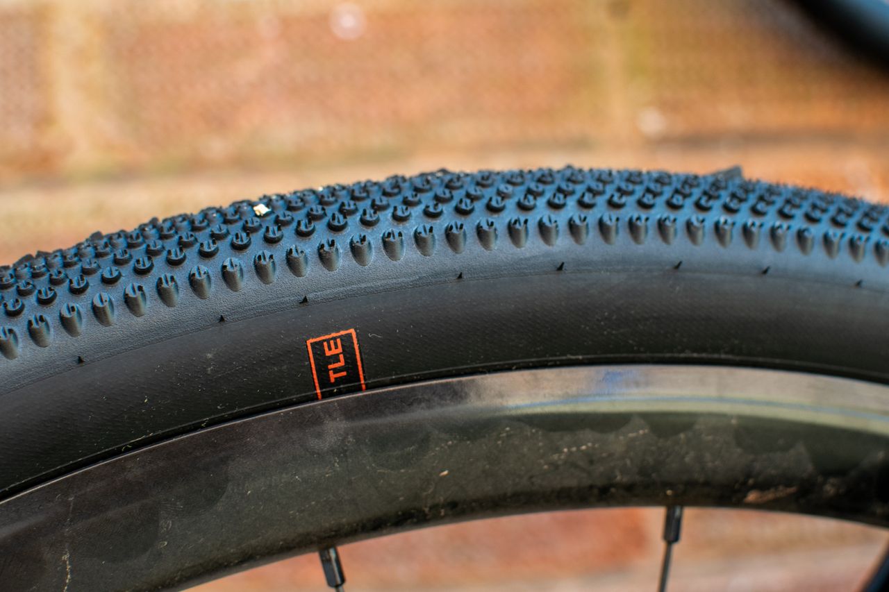 A Schwalbe G One All Round tyre in front of a brick wall