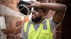 Overheated construction worker wiping sweat off his brow