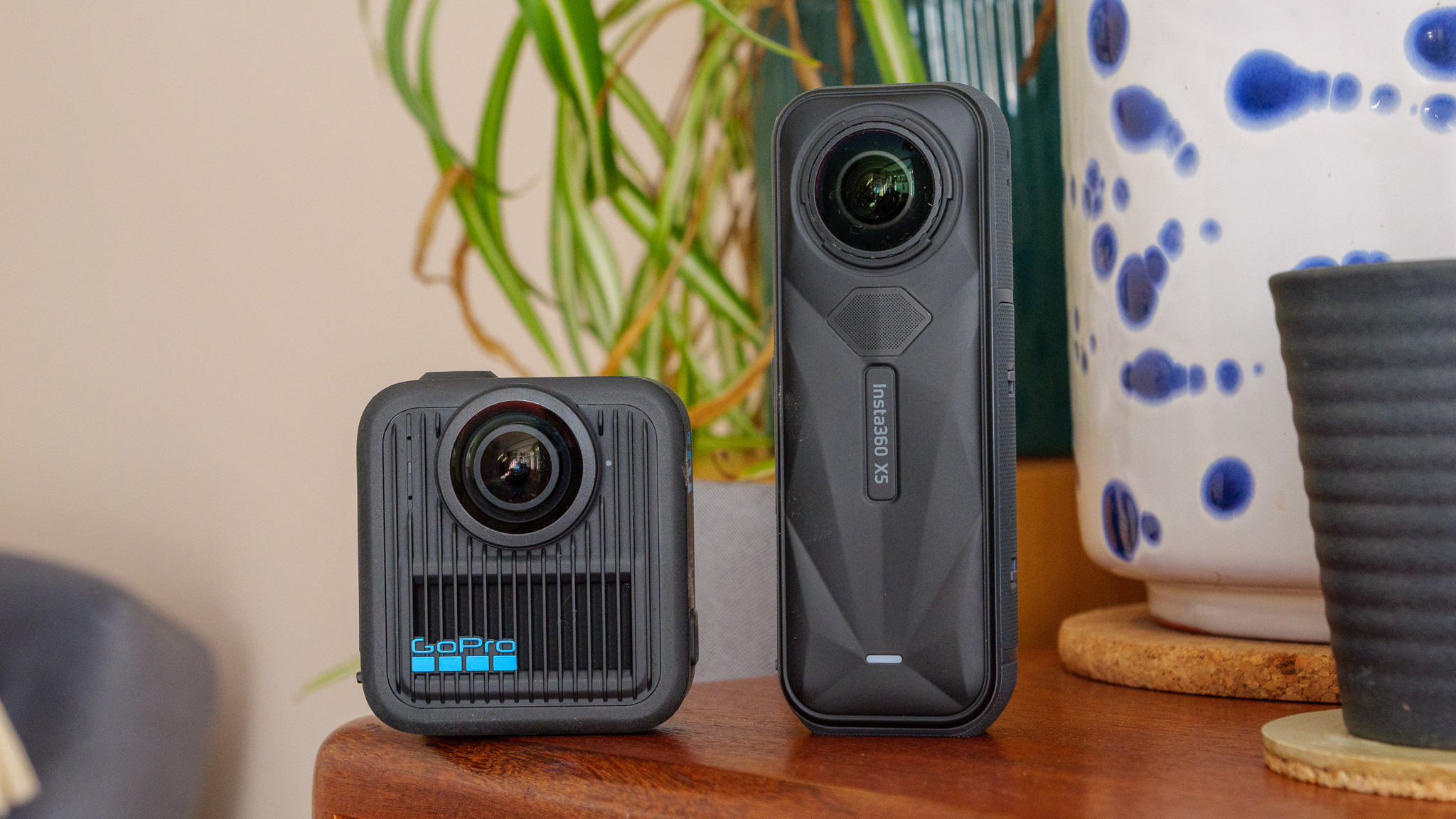 GoPro Max 2 and Insta360 X5 on wooden shelf