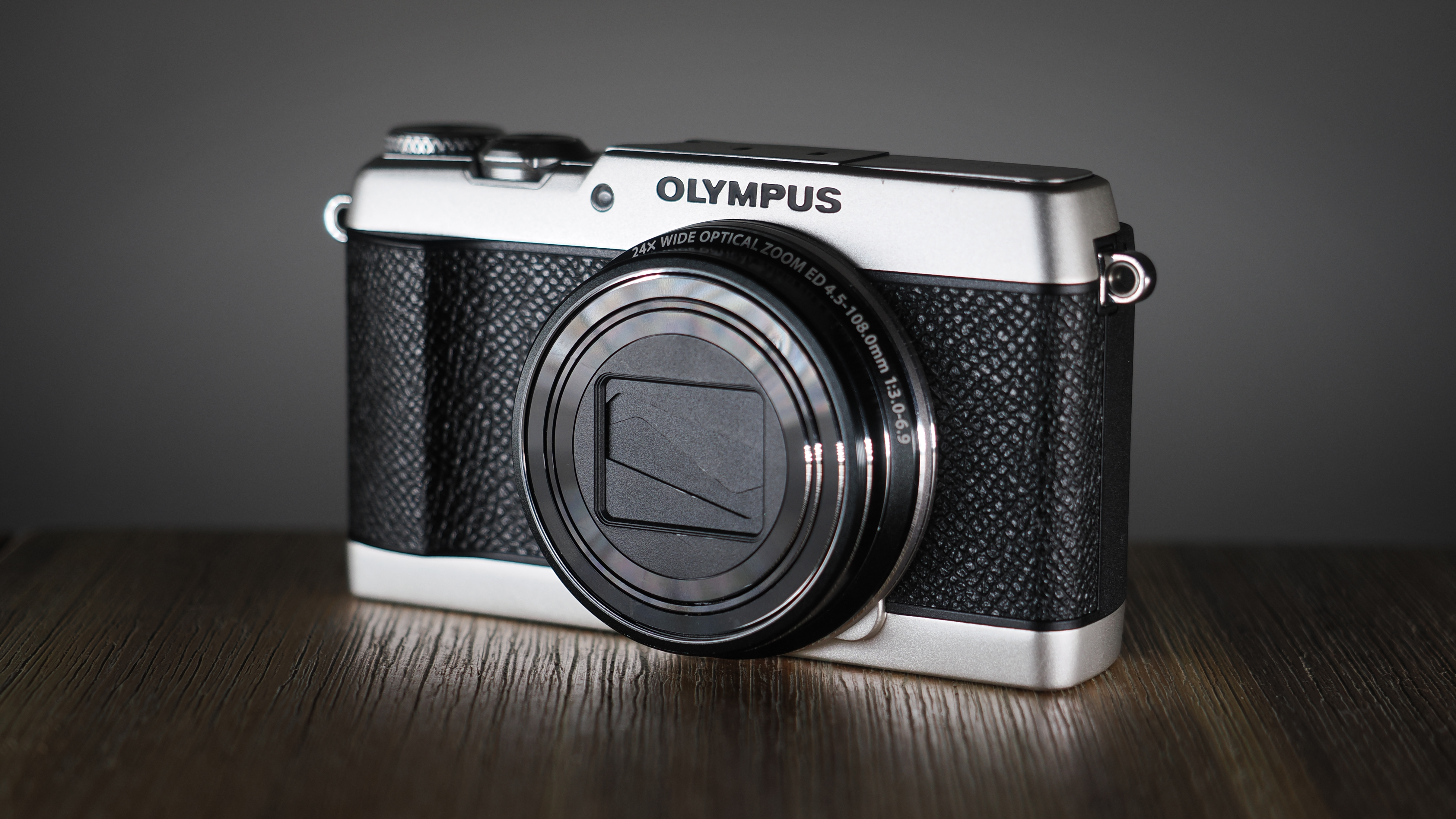 Olympus Stylus SH-3 on a wooden surface