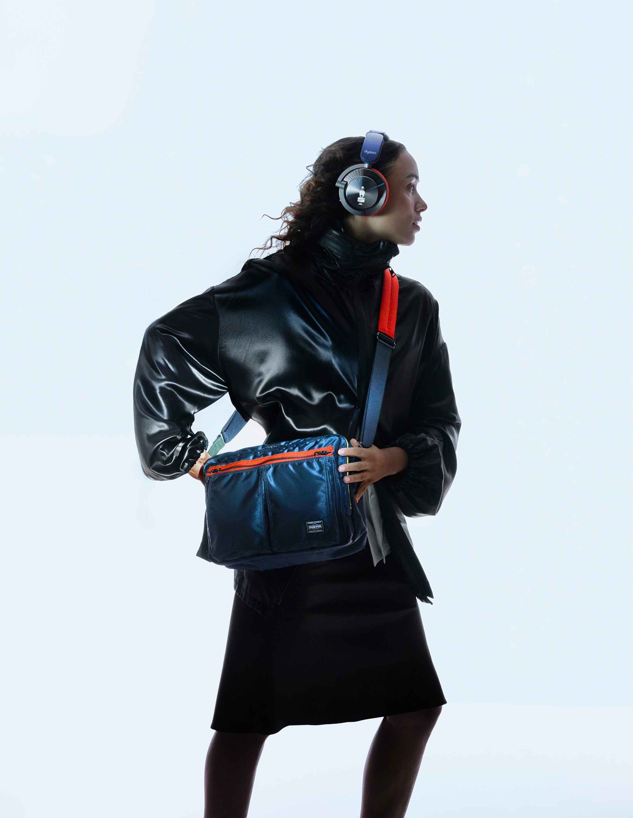 A model wearing the Dyson OnTrac headphones and carrying the Dyson x Porter bag