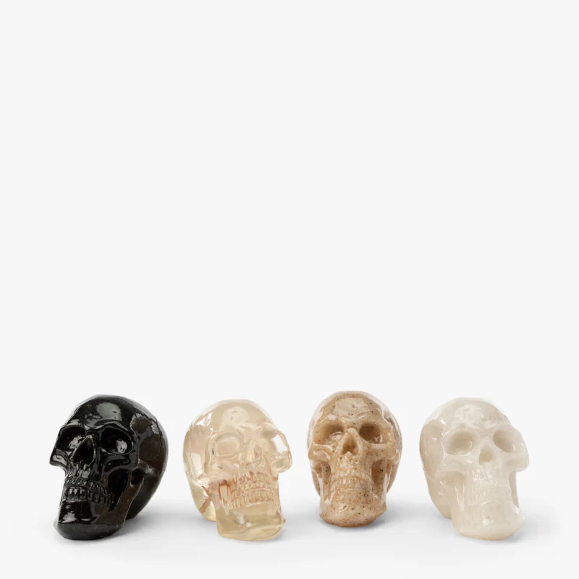 Set of 4 resin skull ornaments in beige, white, clear and black