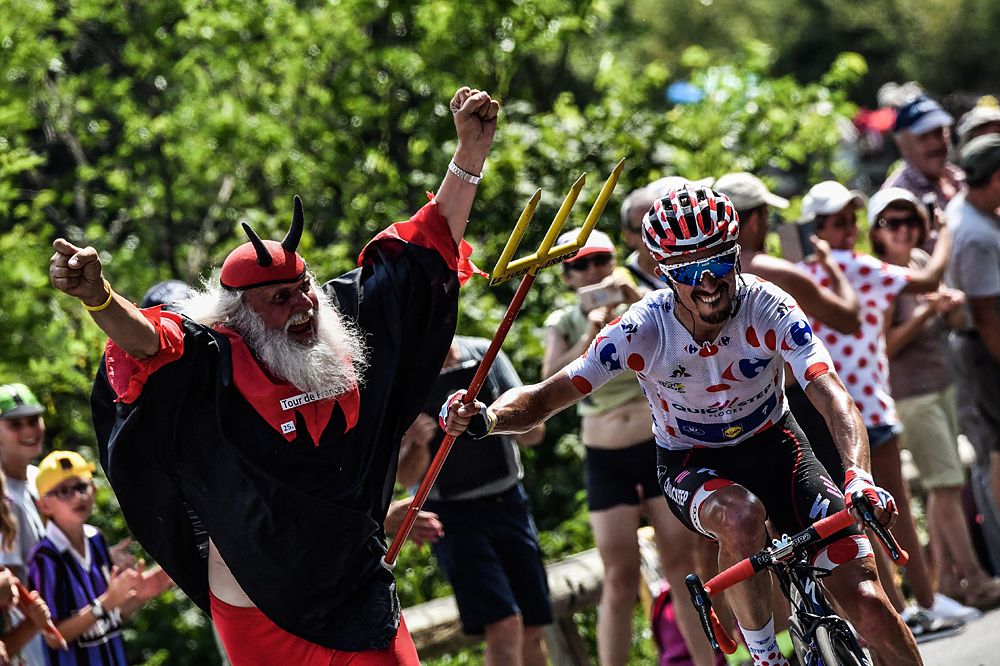 Julian Alaphilippe, wearing the best climber's polka dot jersey (R) seizes the fork of Tour de France fan Didi Senft (L) during the 17th stage