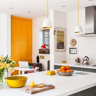 white kitchen with table and orange door