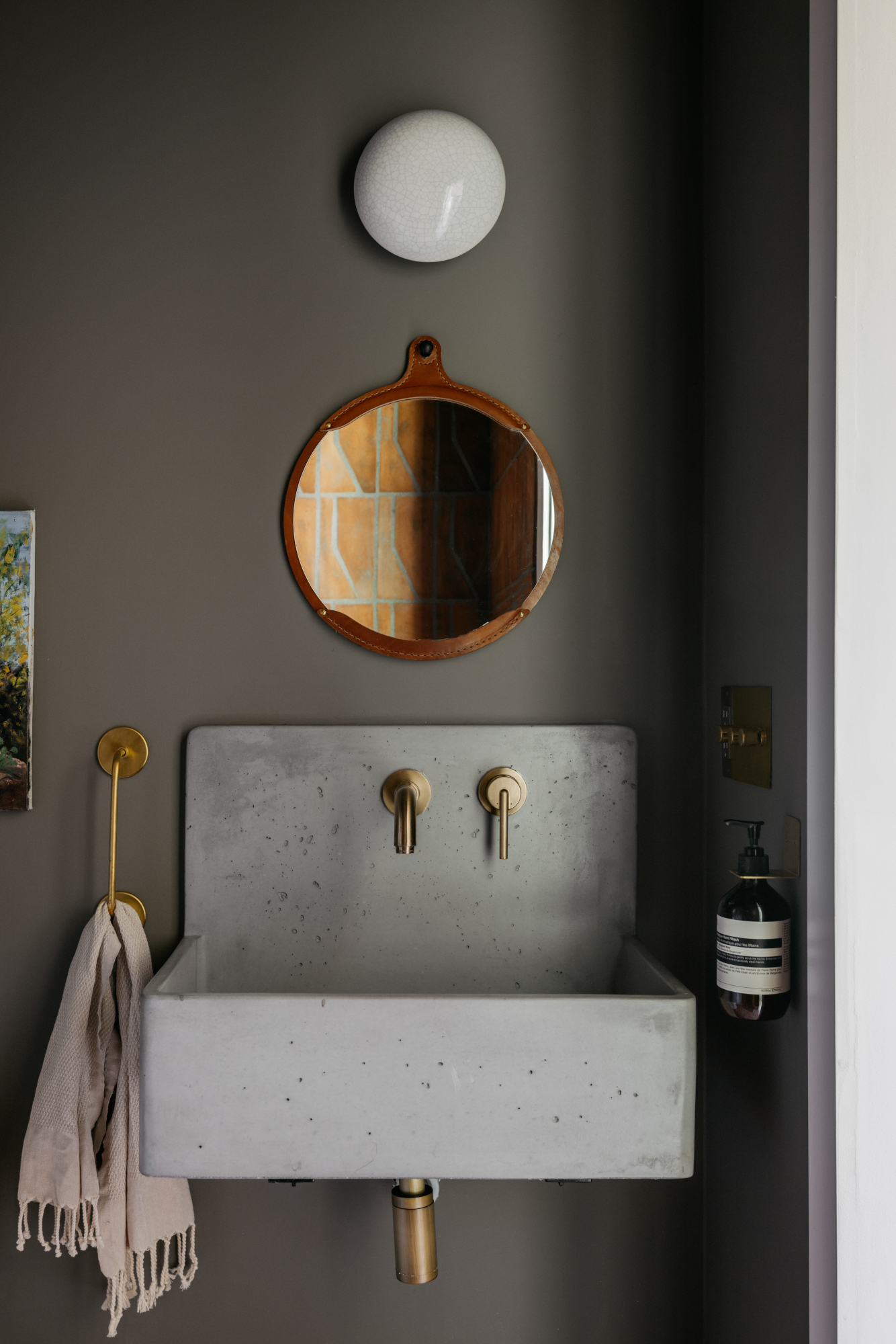 Bathroom with grey-brown walls and concrete wall-hung basin