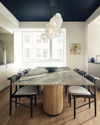 a modern dining room with a dark blue painted ceiling