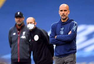 File photo dated 02-07-2020 of Manchester City manager Pep Guardiola (right), Liverpool manager Jurgen Klopp (left) and fourth official Mike Dean on the touchline during the Premier League match at the Etihad Stadium, Manchester
