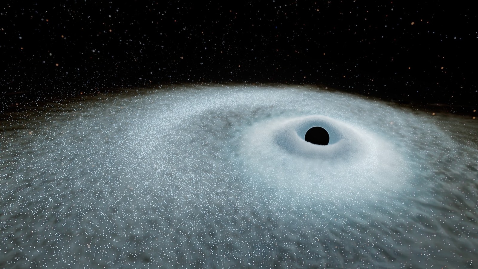 a black orb surrounded by white specks of light, with stars visible in the background