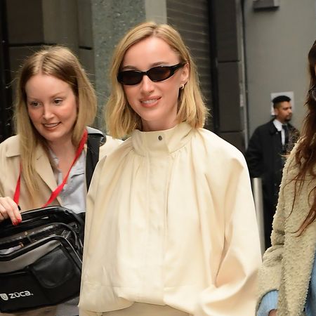 Phoebe Dynevor wearing a cream funnel neck jacket and matching skirt and black flats
