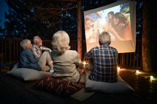 A group of people watch a movie outdoors