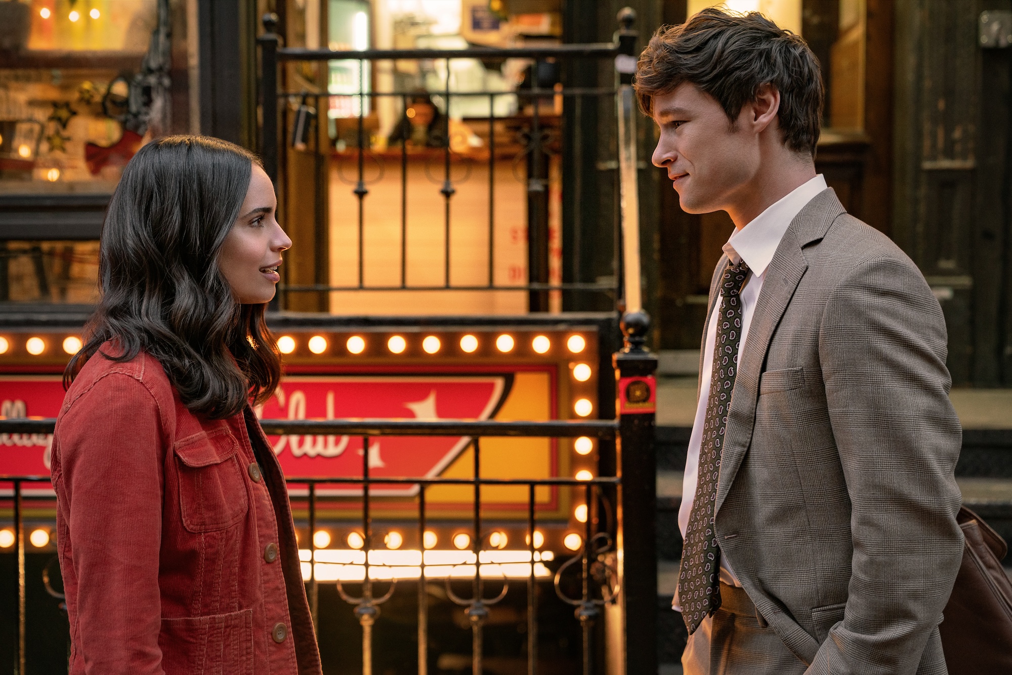 Sofia Carson as Alex and Kyle Allen as Brad, standing in front of gated NYC buildings, in The Life List.