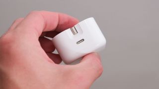Apple 20W wall charger in a hand