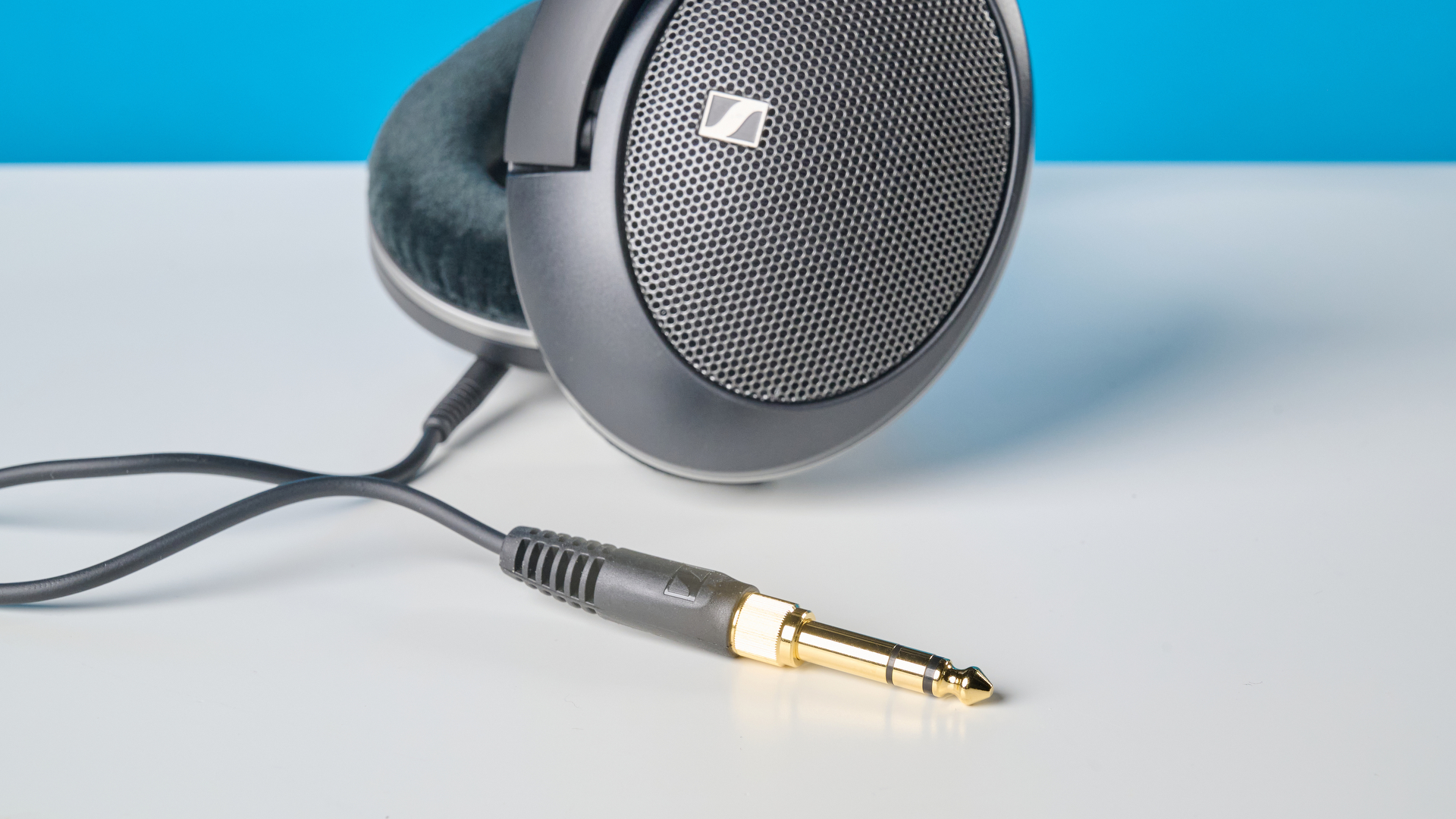 The Sennheiser HD 550 headphones on a stone surface with a blue background