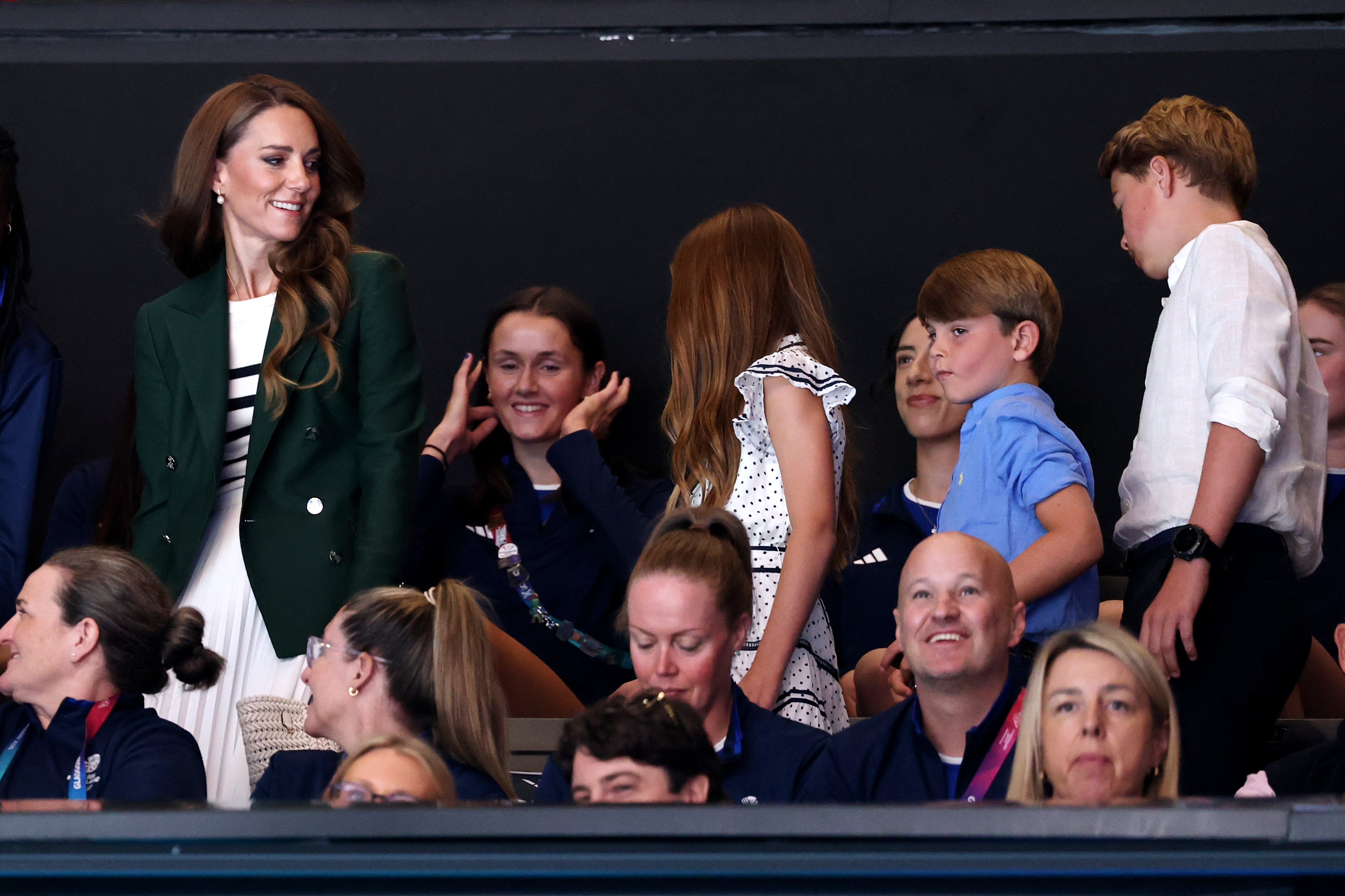 Princess Kate has long curly brown hair and is wearing a Breton striped sweater with a dark green Ralph Lauren blazer at the Commonwealth Games 2026