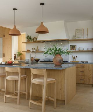 wood cabinetry kitchen with large plastered white range hood