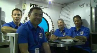 The NEEMO 18 crew participates in a news conference from the Aquarius underwater lab, just off the coast of Key Largo, Florida. From left, European Space Agency astronaut Thomas Pesquet, Japanese astronaut Akihiko Hoshide and NASA astronauts Mark Vande Hei and Jeanette Epps.