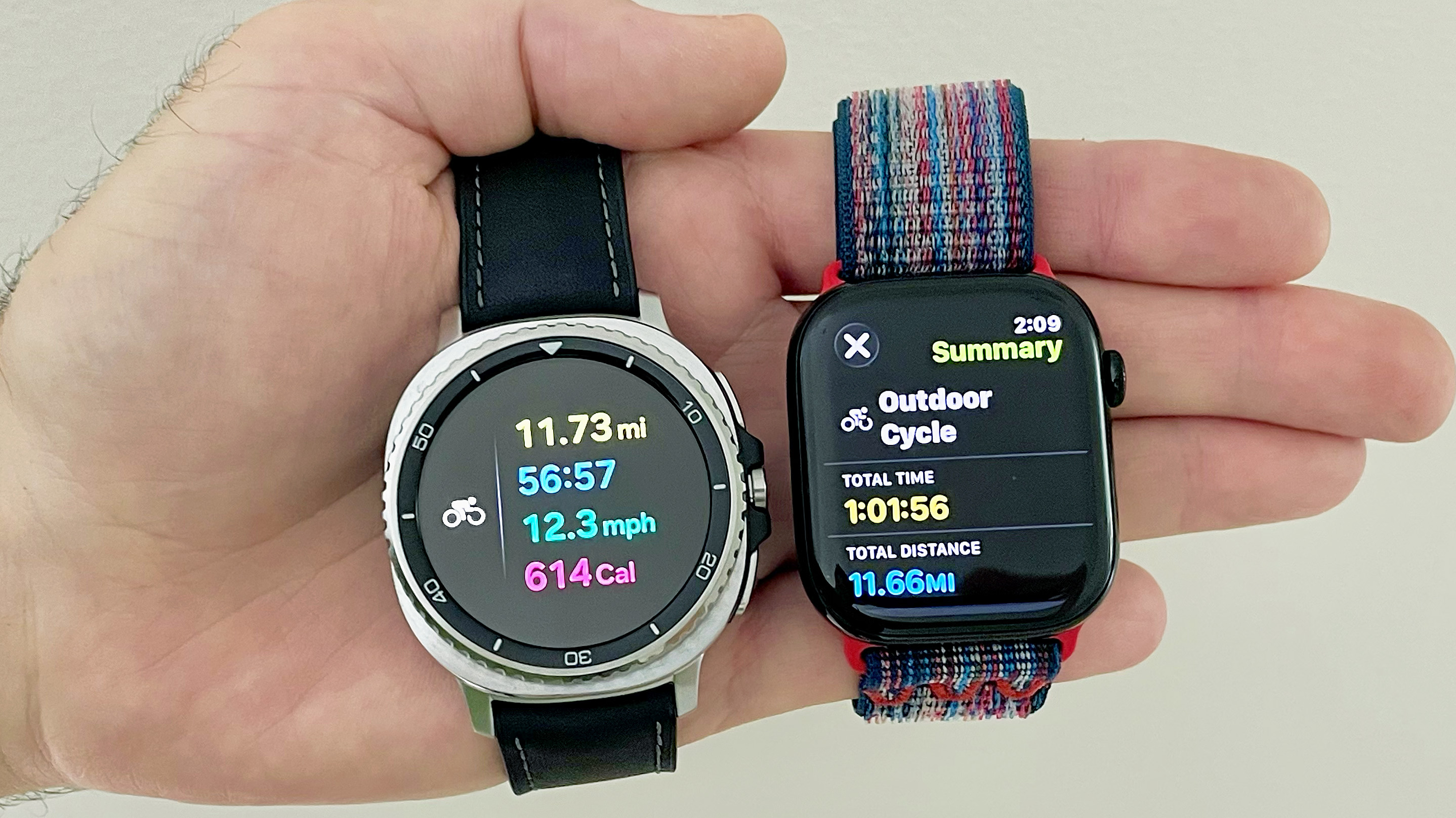 Close-up of the Apple Watch Series 10 and Samsung Galaxy Watch 8 Classic in a user's hand showing the results of a logged bike ride