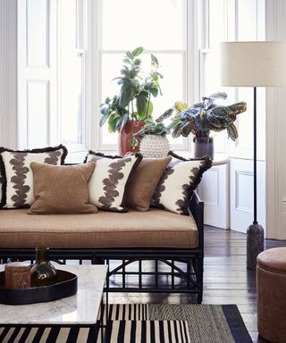 A living room with brown sofa idea with dark brown and white cushions, and black and white rug