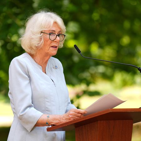 Queen Camilla giving a speech in front of a tree