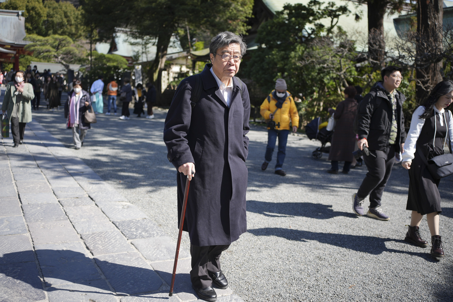 Street photo of elderly man with walking stick in Japan