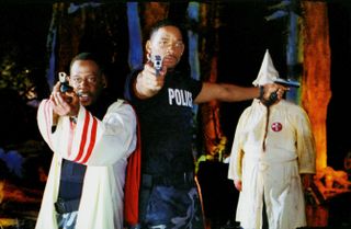 (L to R) Martin Lawrence as Marcus in a Klan robe and Will Smith as Mike in his cop uniform, pointing guns in Bad Boys II, one of the best Netflix comedies