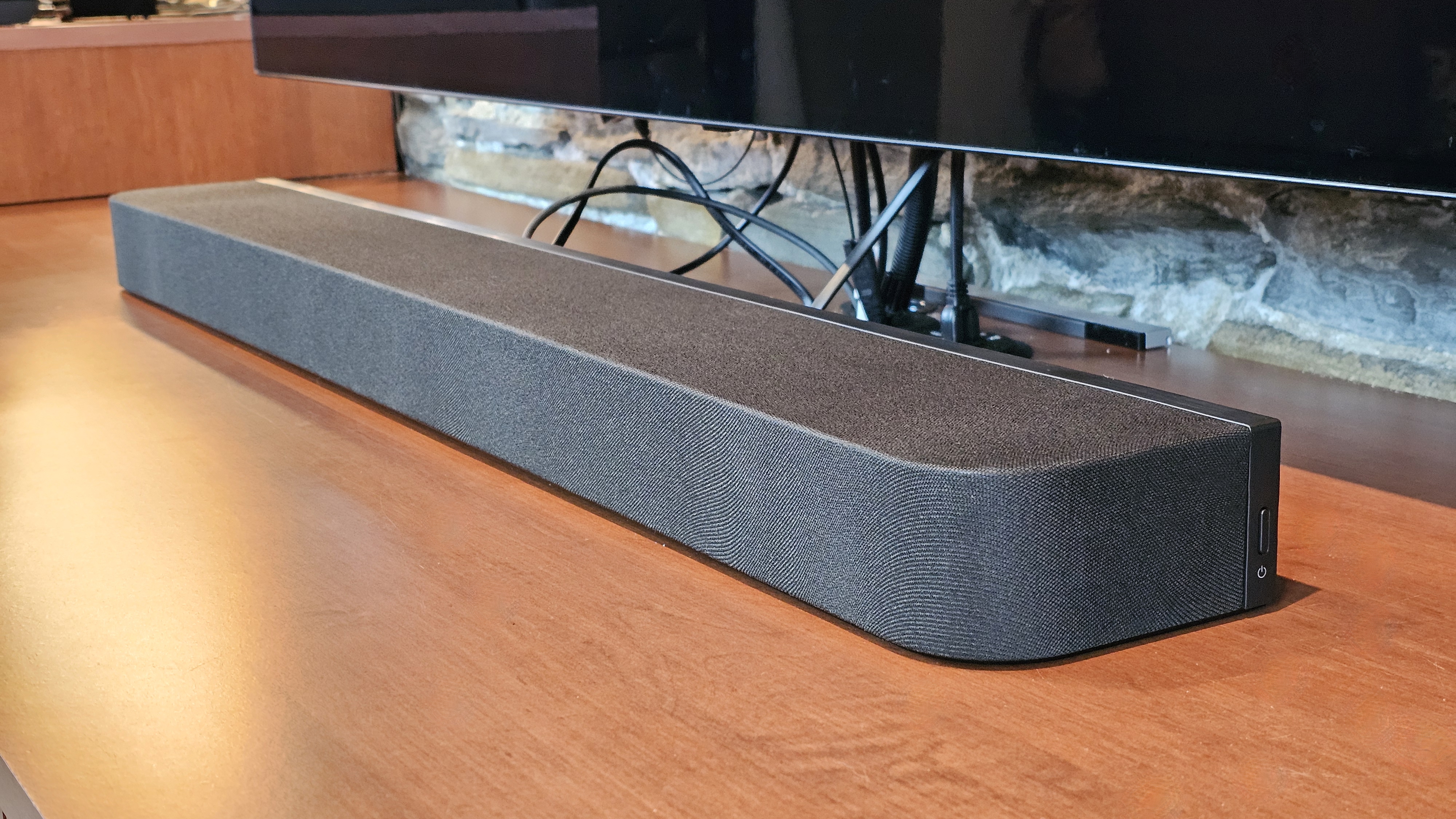 The Sony Bravia Theater Bar 7 pictured on a wooden cabinet under a television
